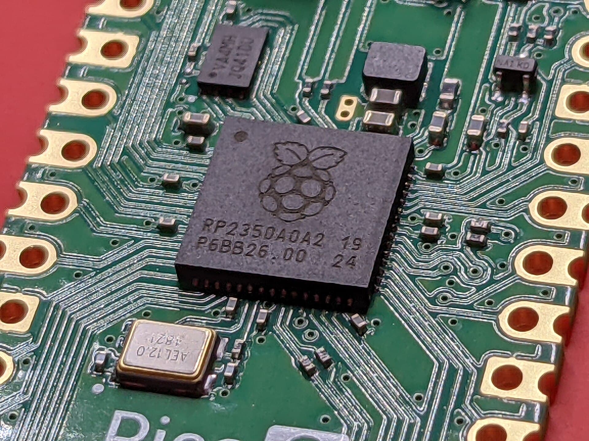Macro photograph of a microcontroller chip on a green circuit board